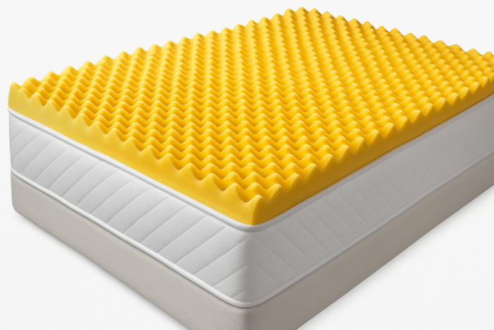 Yellow convoluted foam mattress topper placed on a white mattress